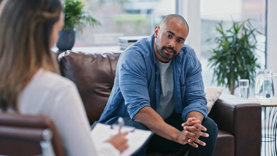 Person sitting on couch talking to therapist