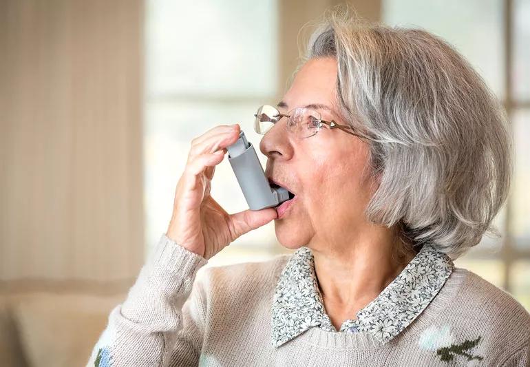 elderly woman using inhaler for asthma attack
