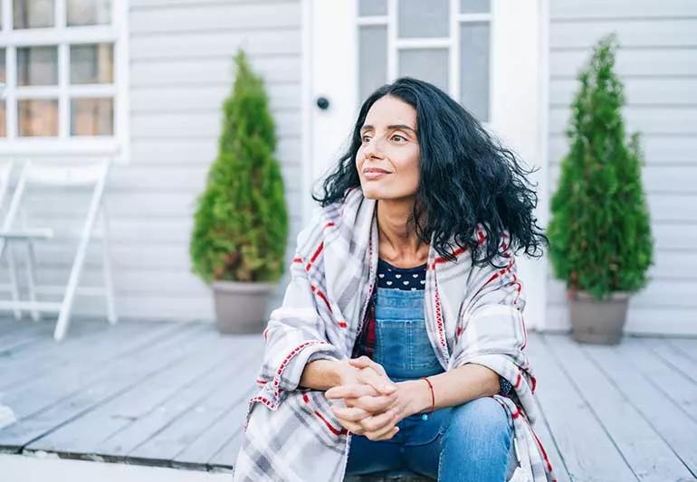 Mid 40's woman sitting on back porch.