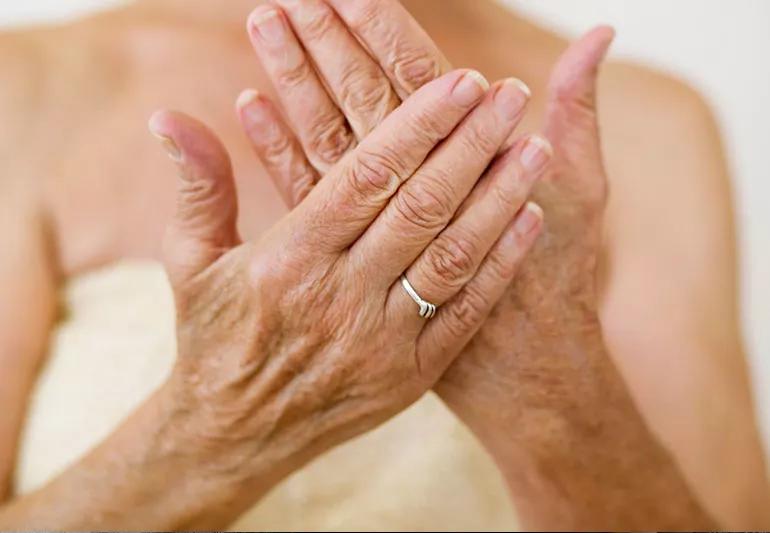 elder woman moisturizing hands