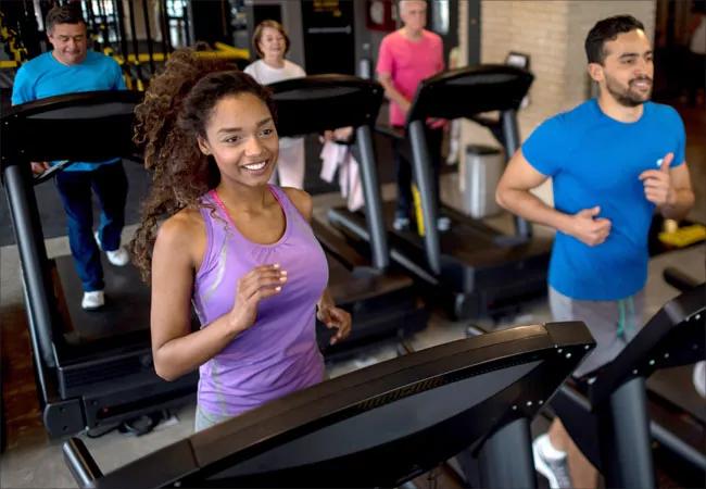 A group of people running on treadmills.