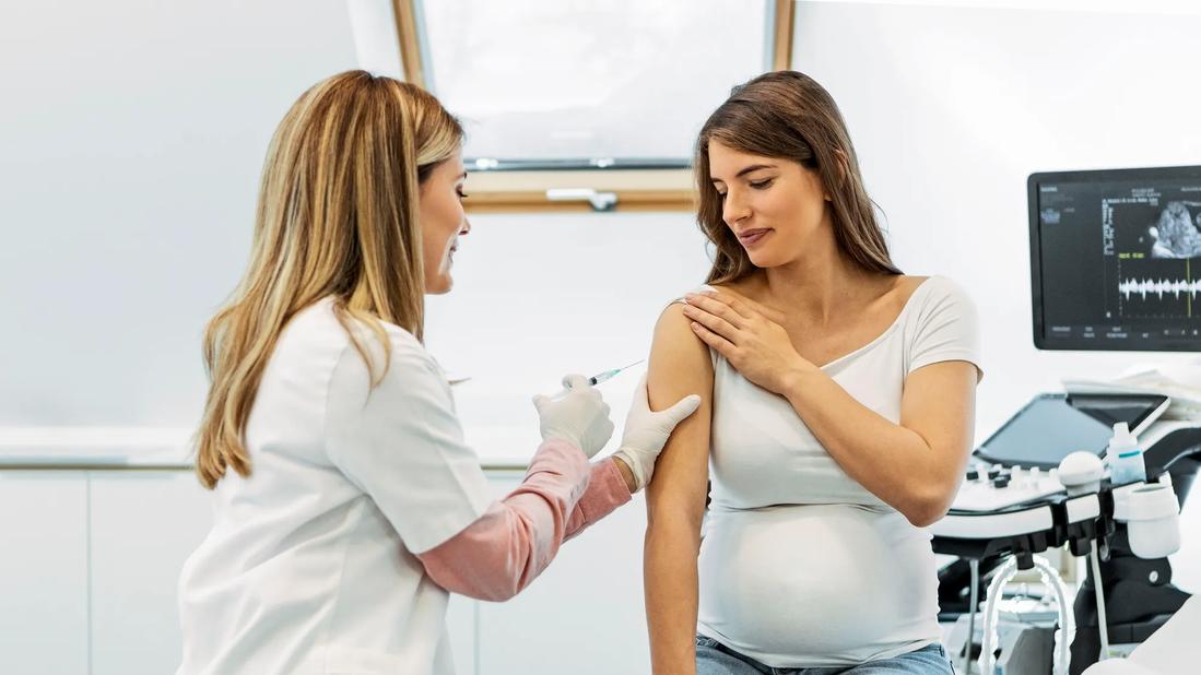 Healthcare provider giving pregnant patient a shot