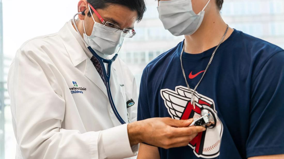 Doctor uses stethoscope on teen boy