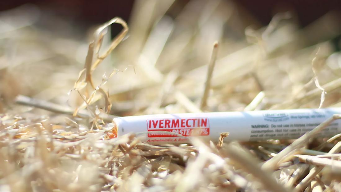 Tube of ivermectin paste lying on straw