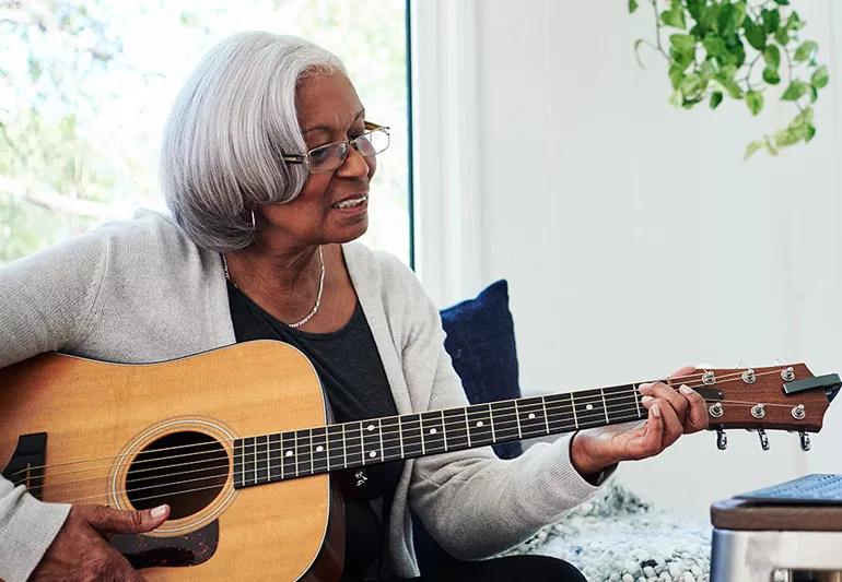 Retired woman learning to play guitar