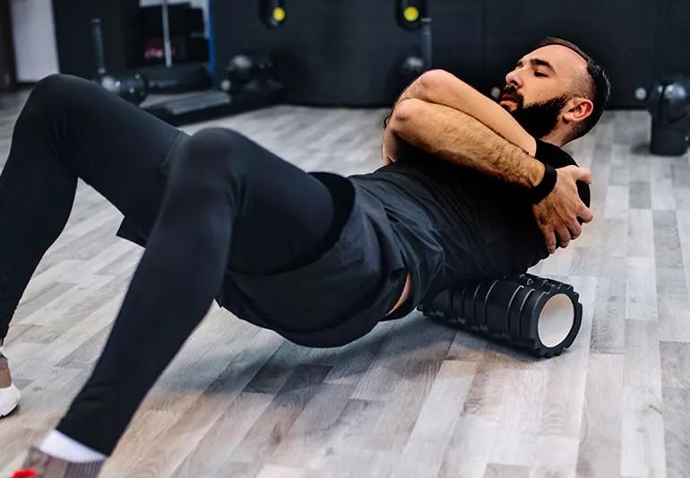 man using roller on back