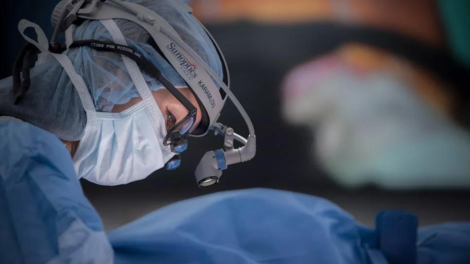 Surgeon wearing a surgical cap, glasses and mask