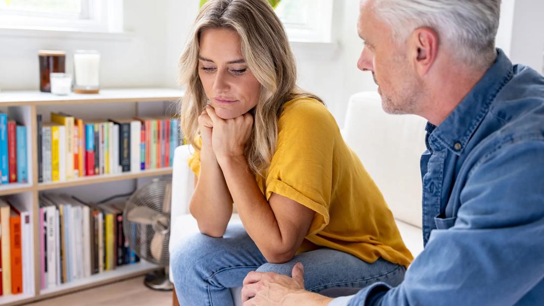 Couple sitting couch looking sad