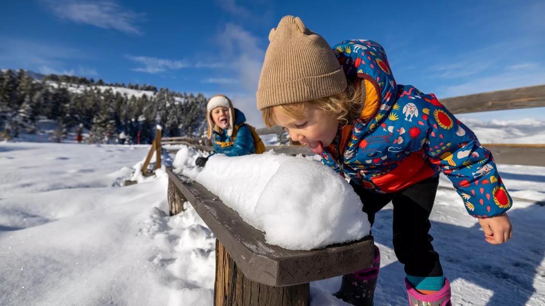 two kids eating snow outside