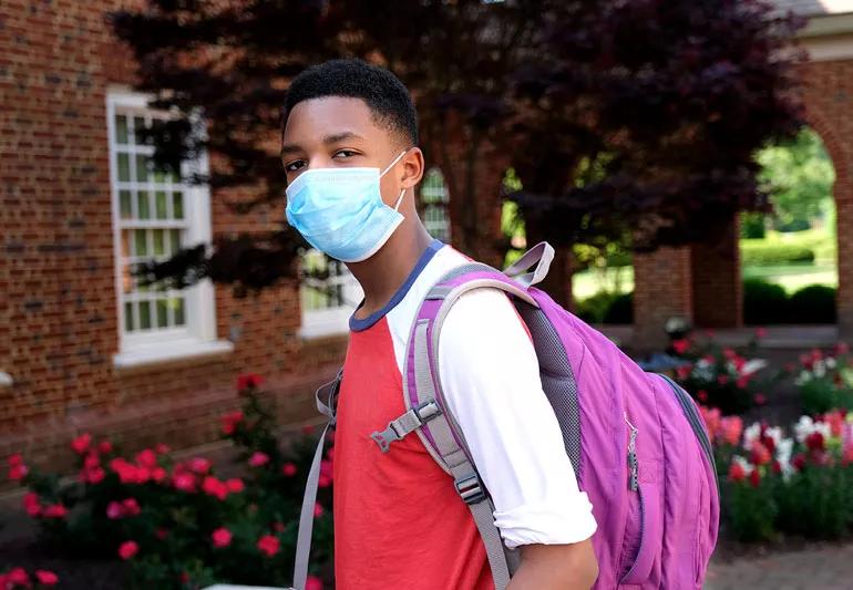 Teenager with covid mask entering school