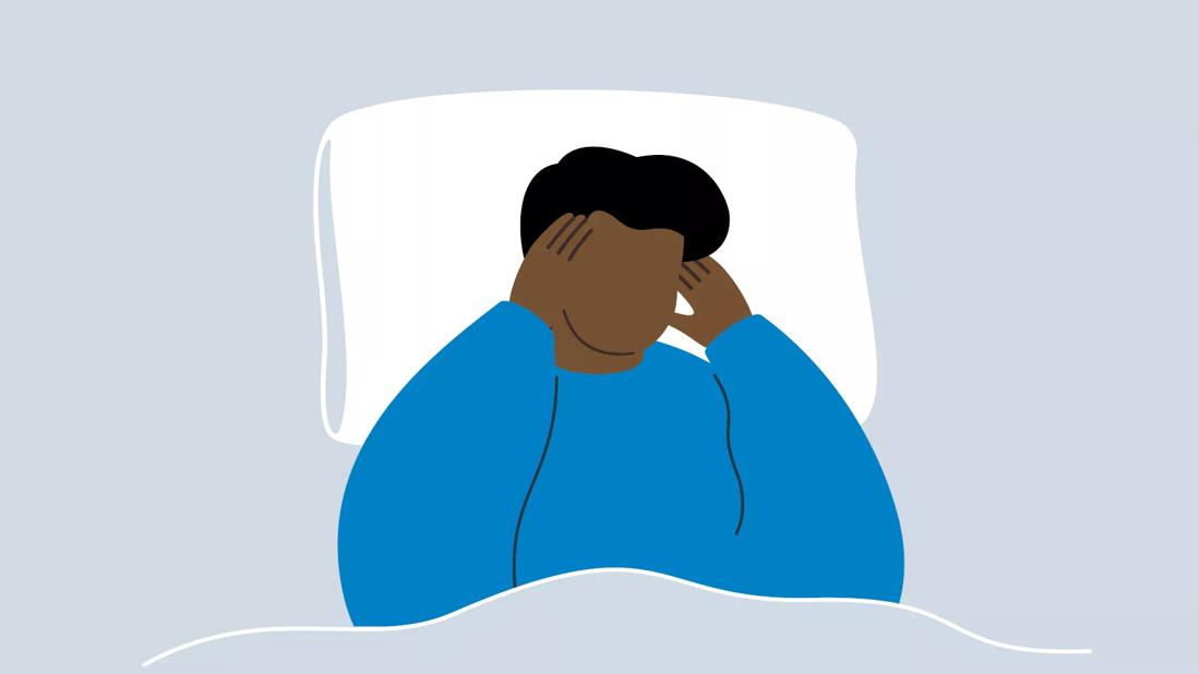 An illustration of a person laying in bed and holding their head in pain