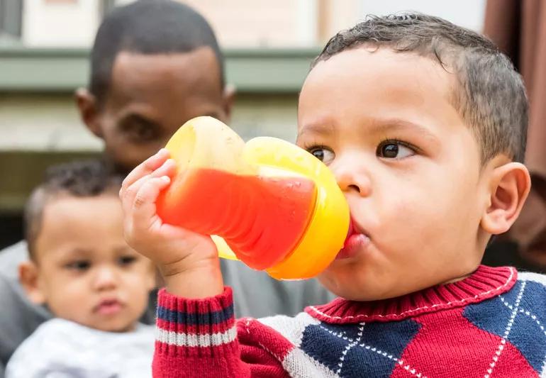 Little boy drinking juice from bottle