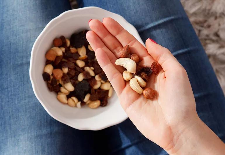 woman snacking on raisins and nuts