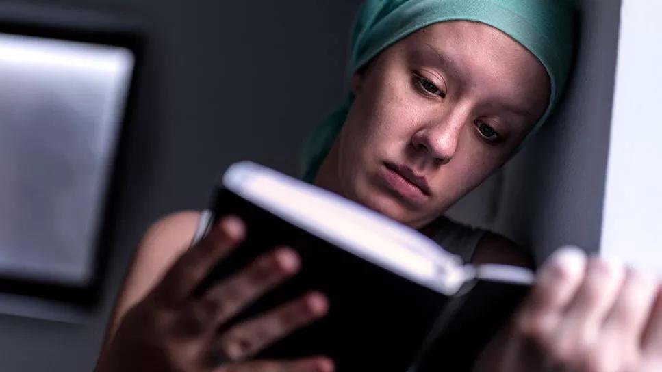 Tired cancer patient reading at night