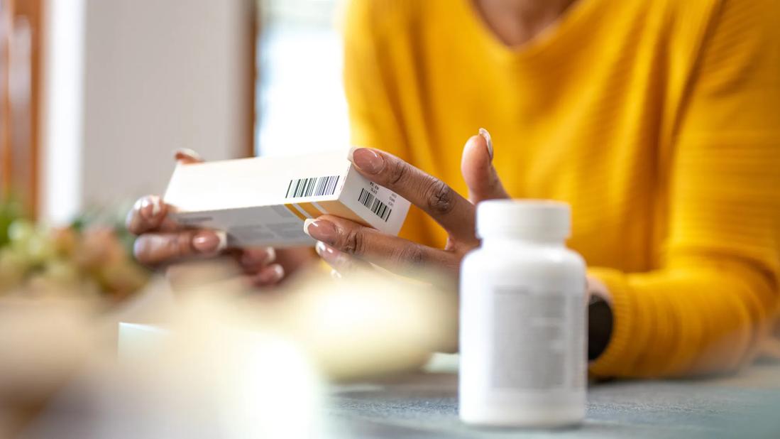 Woman at home with medication box