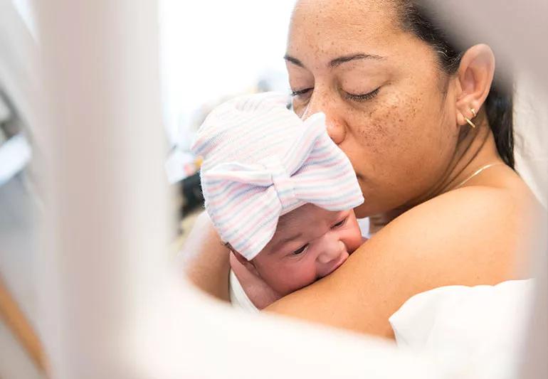 A person holding a newborn baby