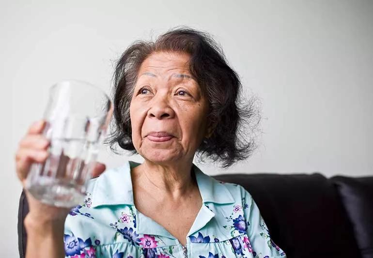 older woman drinking a glass of water