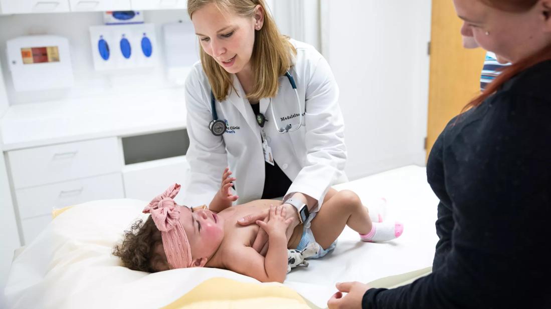 Physician caring for infant on exam table