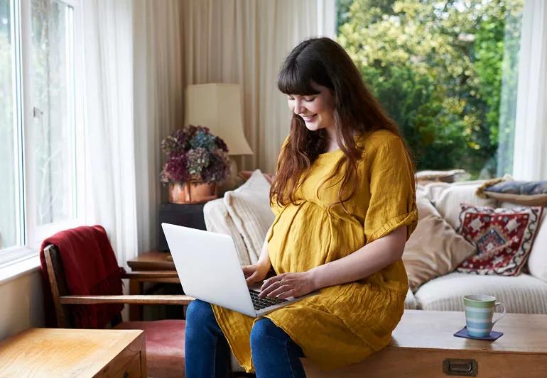 pregnant woman at home on computer