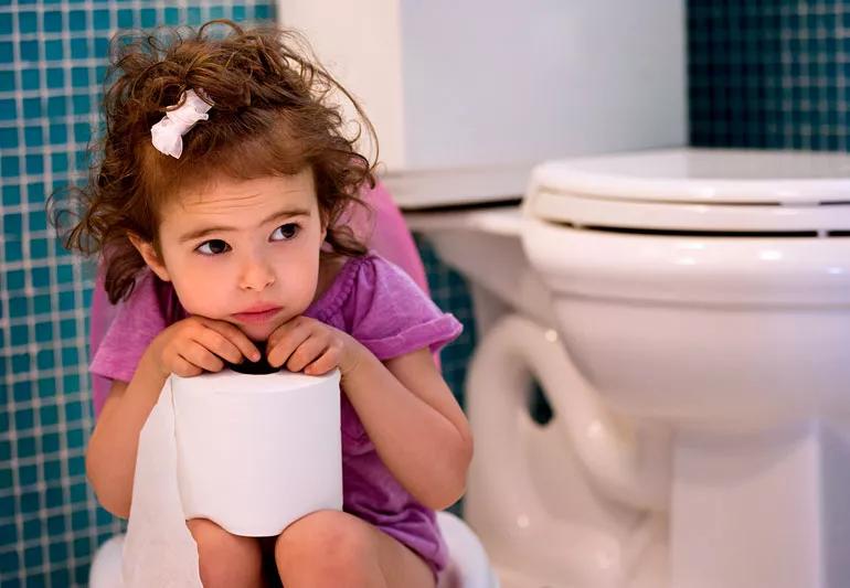 sad little girl with UTI sitting in bathroom