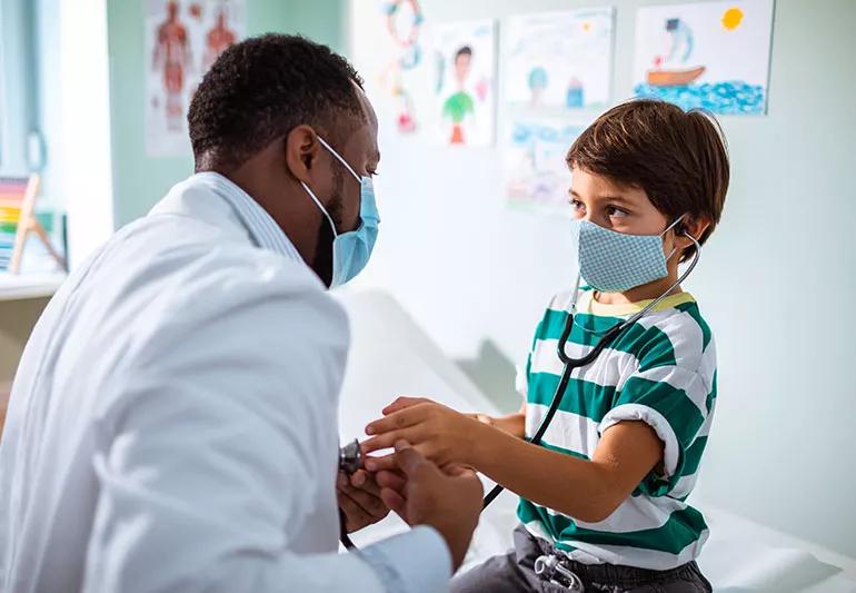 pediatrician playing with child at doctors office