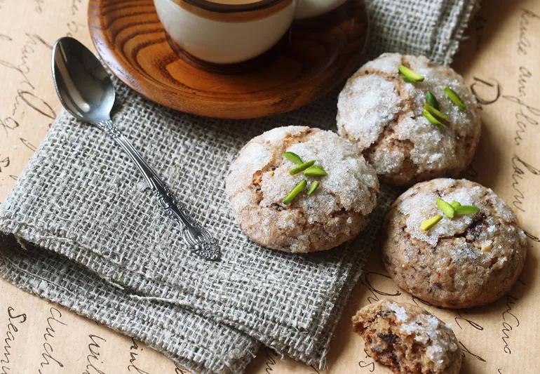 Sugar-coated gingerbread cookies on table, with cup of coffee and spoon