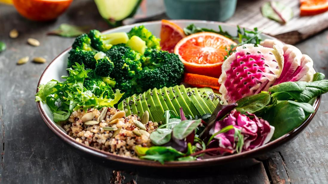 Plate full of colorful and healthy fruits, veggies and grains