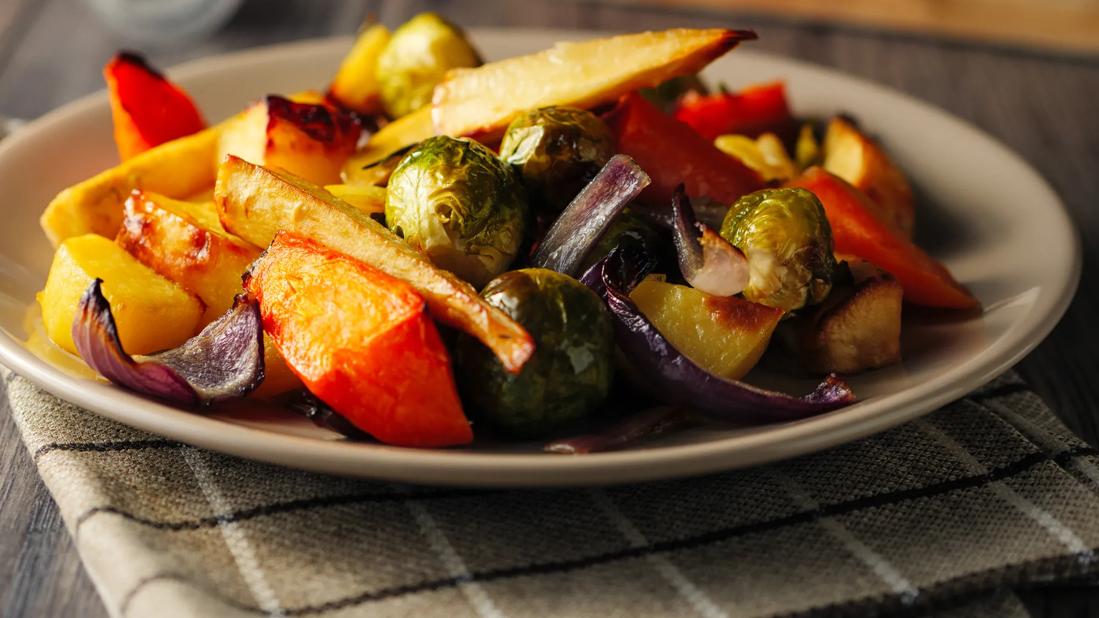 Plate of roasted winter vegetables, with Brussels sprouts, peppers , onions