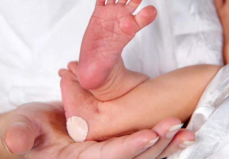 newborn with heel prick and bandaid
