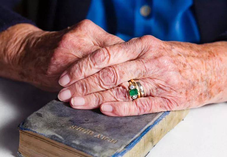woman's hands with age spots holding bible
