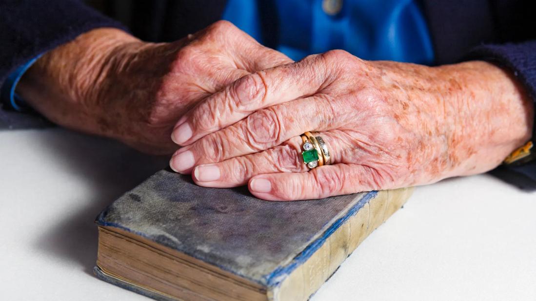 woman's hands with age spots holding bible