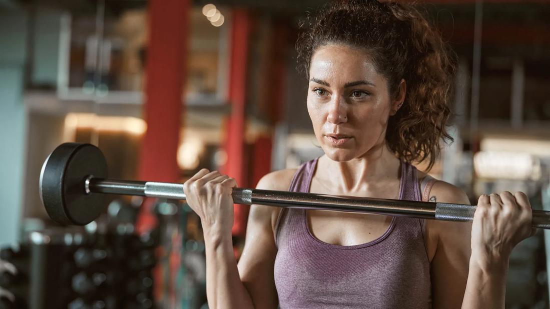 Person lifting a barbell in a gym