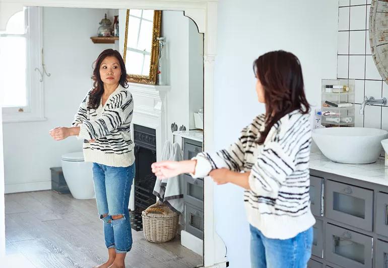 woman looking in mirror and not judging