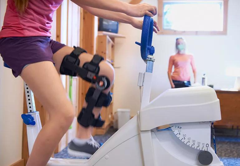 woman working on her leg in rehab