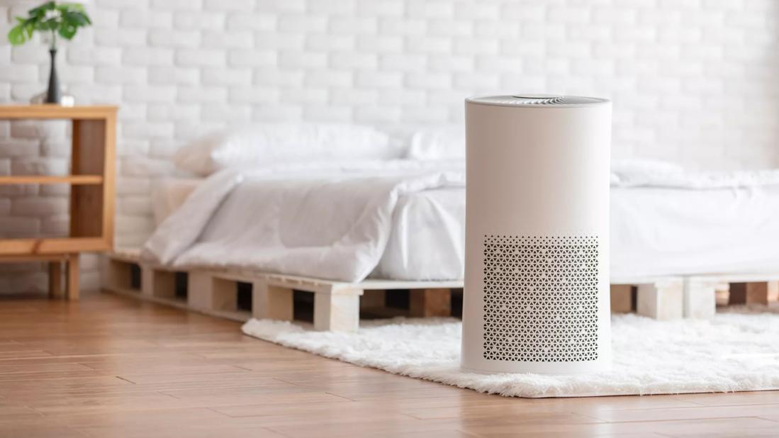 Air purifier in cozy white bedroom
