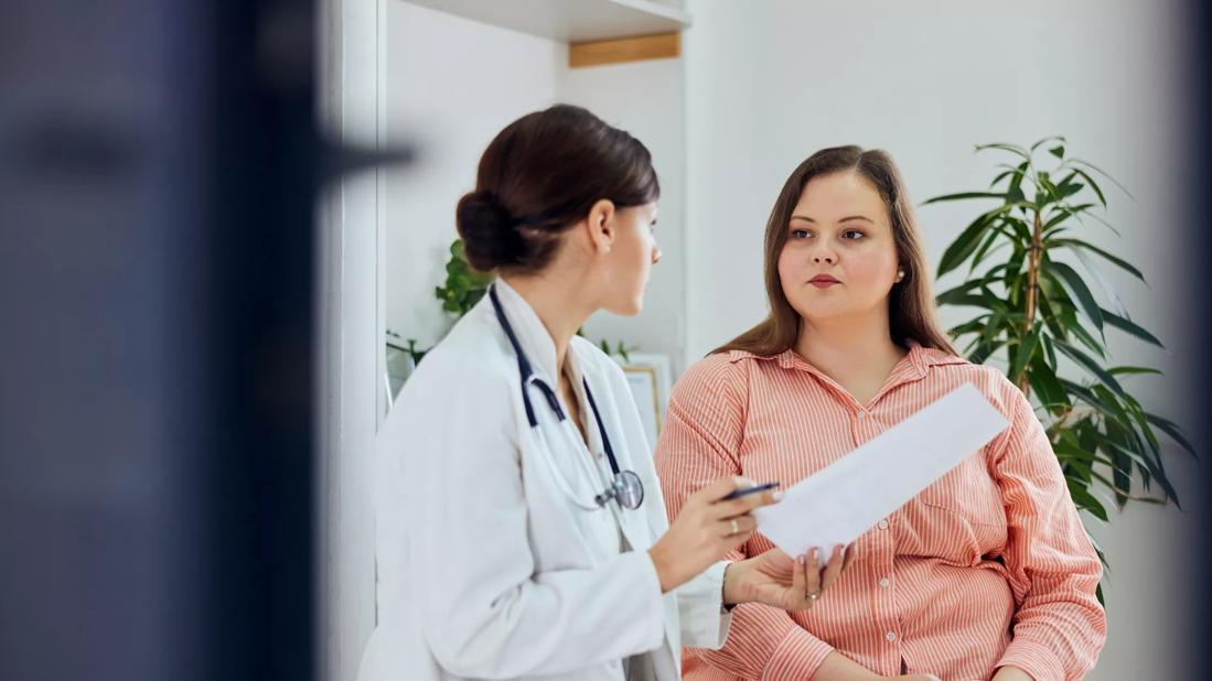 Healthcare provider talking with patient with overweight in office