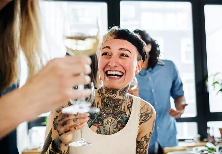 Person flushed when drinking wine at a friend's party.