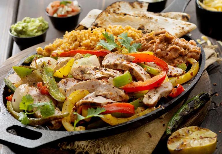 Mexican food on a platter beans rice vegetables meat