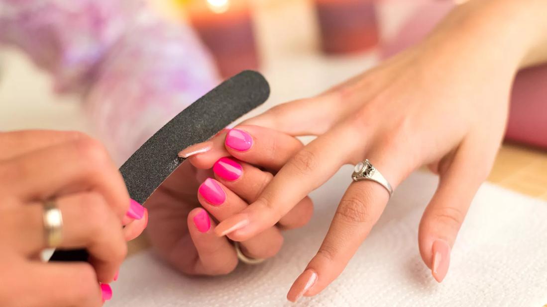 Acrylic nails being filed by manicurist