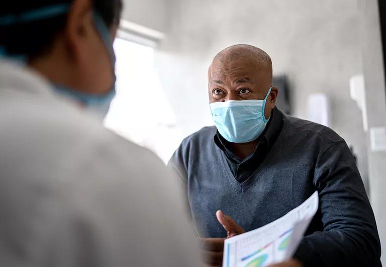 Elderly man talking with doctor at his appointment.