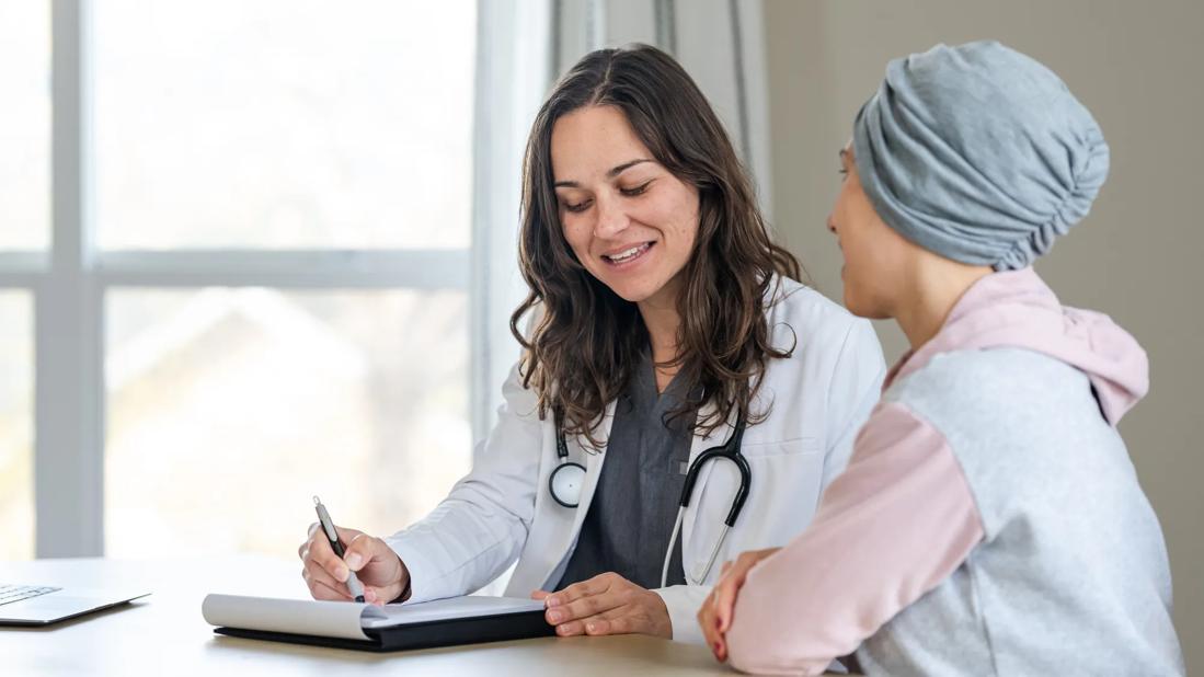 Female in hair wrap talking with healthcare provider in office