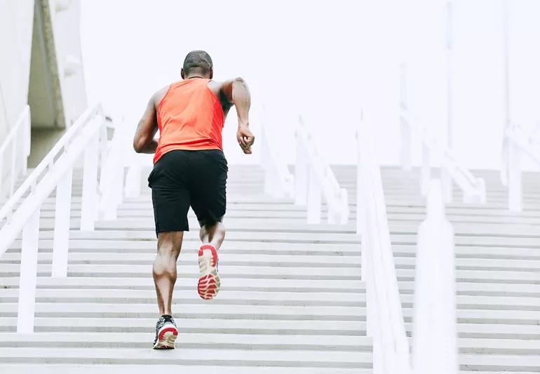 athlete runs up stairs in city