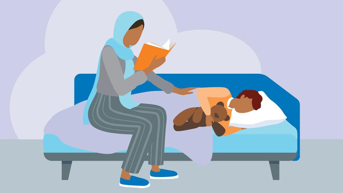 Parent reading to their sick child who is in bed.