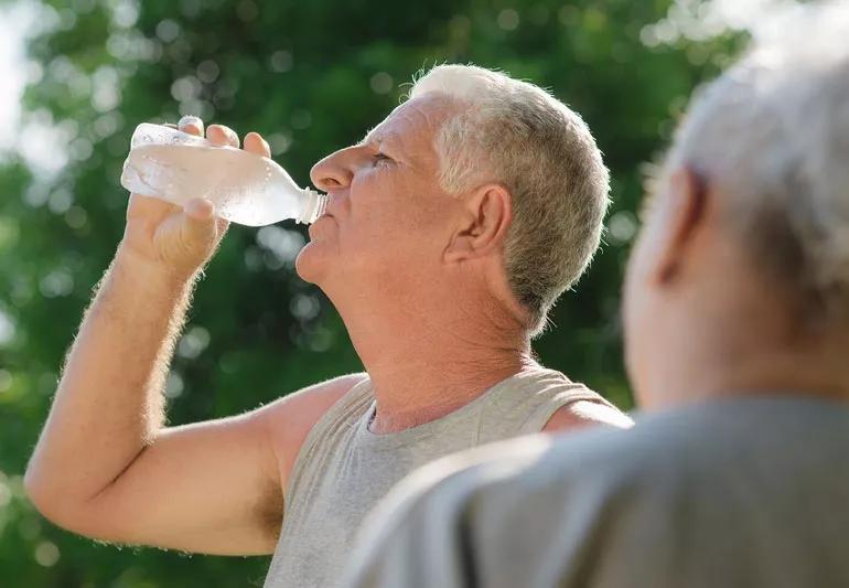 Older man drinking water after working out