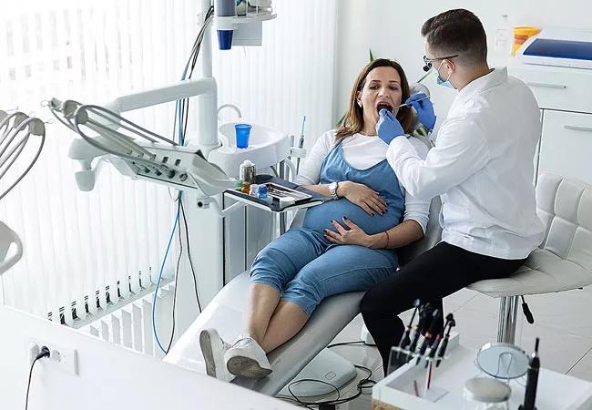 Pregnant woman sees dentist for routine exam