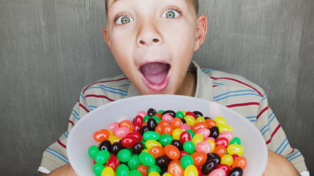Child holding bowl of jellybeans