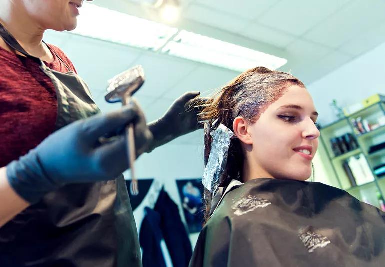 Cororist dying her clients hair at a salon