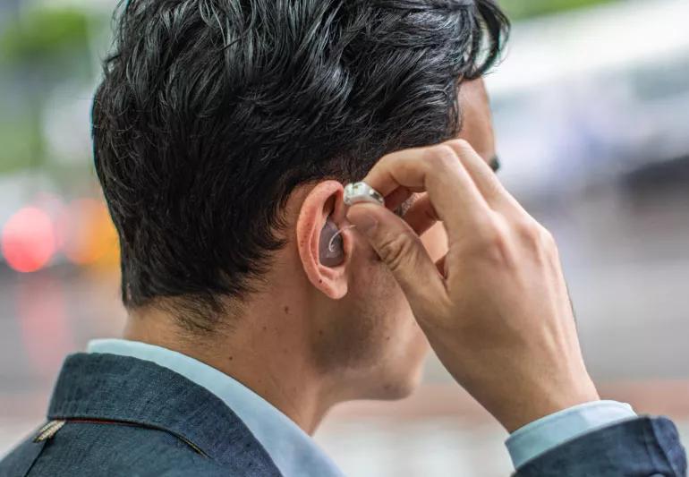 Man fixing hearing aid