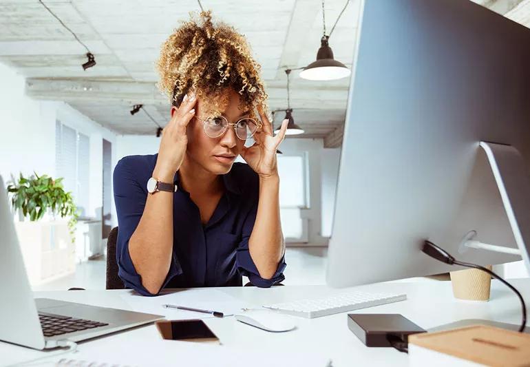 woman with headache while working with computer