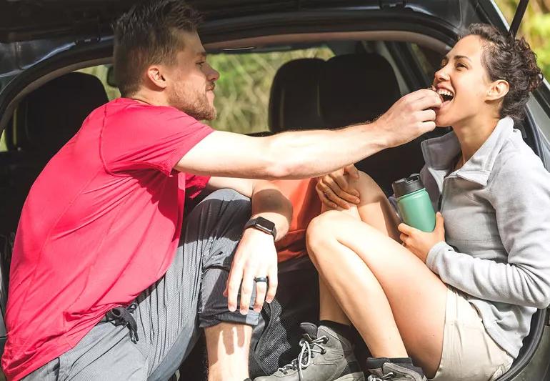 Couple relaxing and snacking after hike